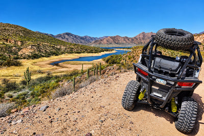 Lifted Polaris RZR Trail 900 rear view showing increased ground clearance on rocky trail.
